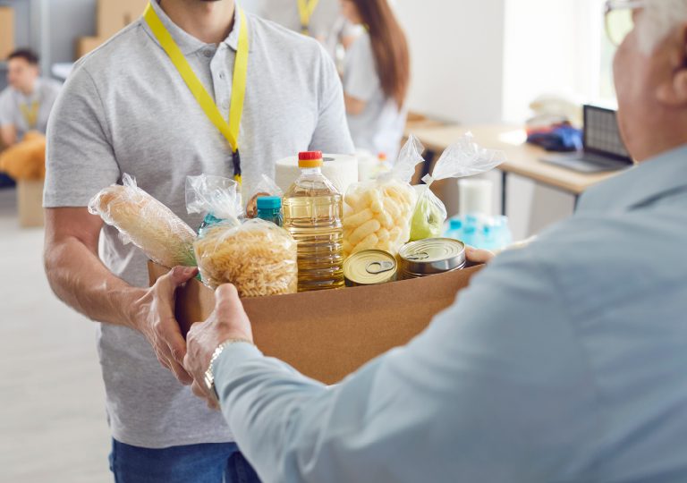 Image of elderly being handed a bag of groceries representing food pantries in Tampa