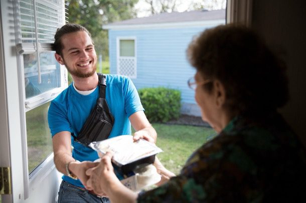 how to qualify for meals on wheels of Tampa -image of person receiving mean from a volunteer