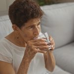 Elderly woman drining water representing hydration for seniors