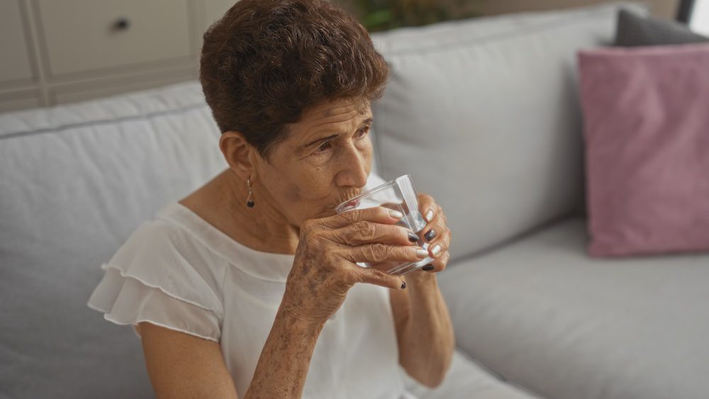Elderly woman drining water representing hydration for seniors