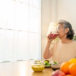 Asian woman drinking orange juice representing The Best Fruits and Vegetables for Seniors
